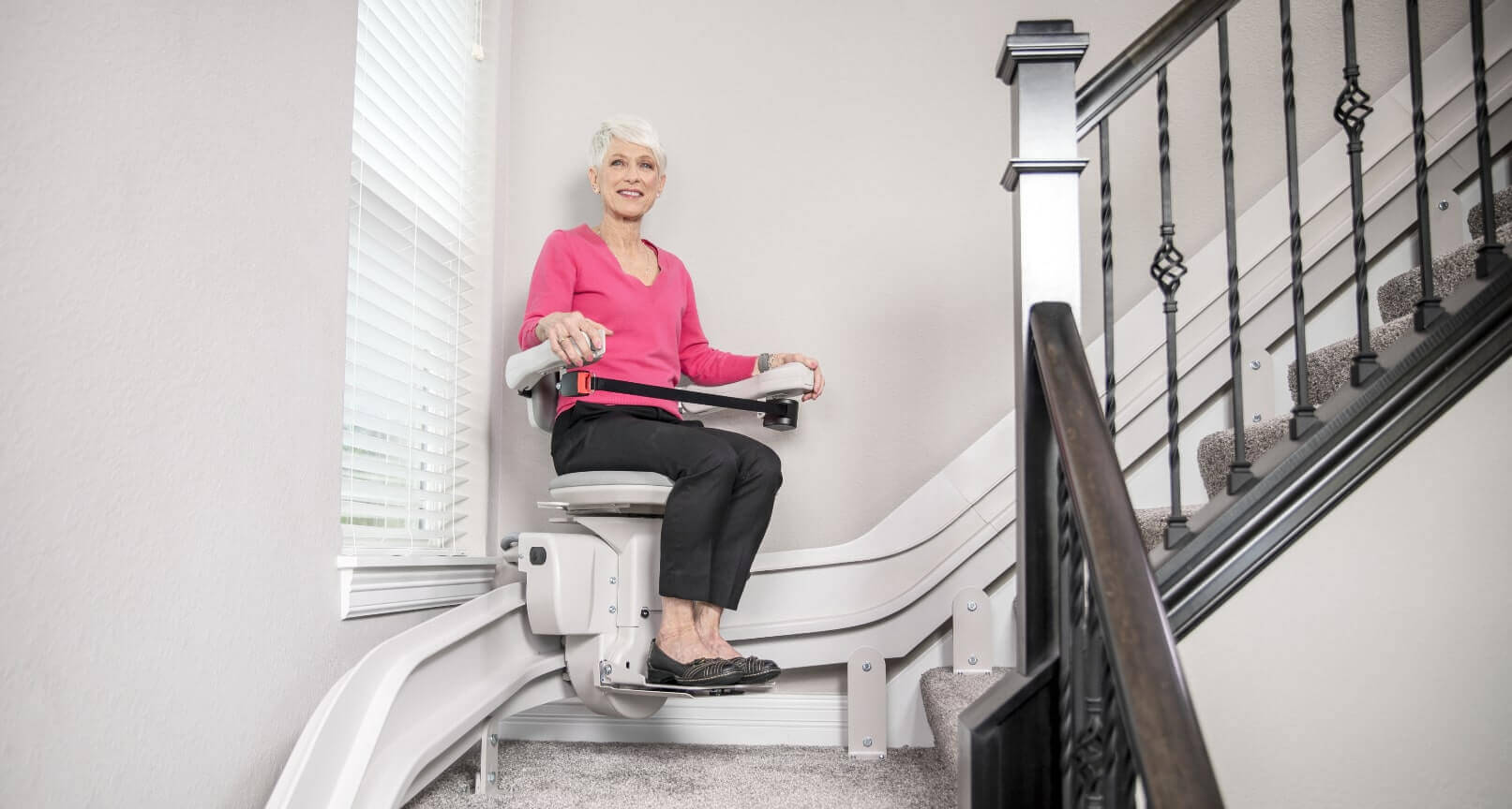 woman riding elite curved stairlift