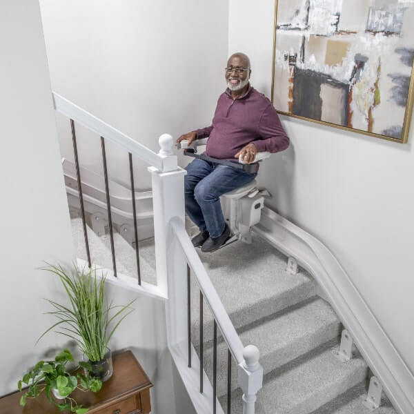 man riding curved bruno elite stairlift
